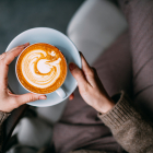 Flat lay woman hand holding latte coffee