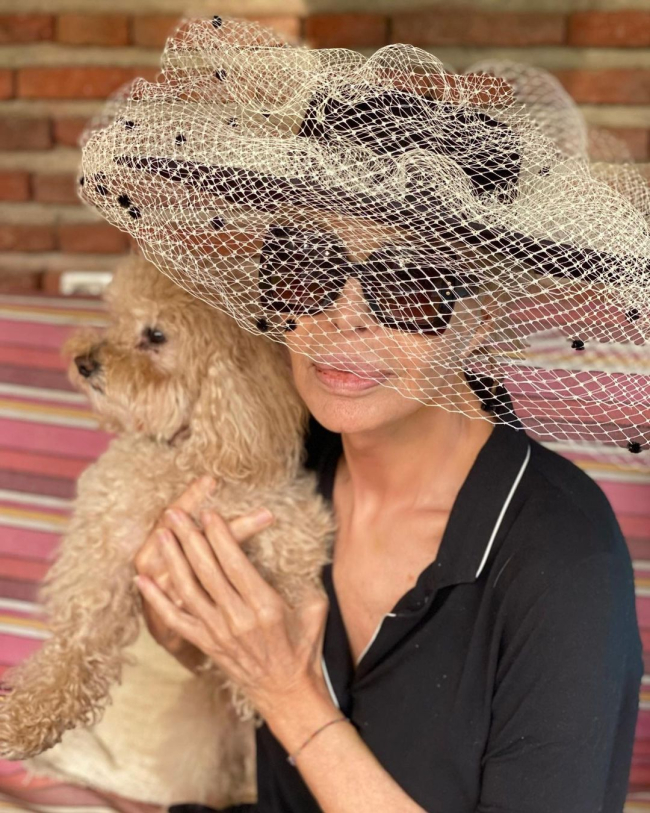 Bibiana Fernández con sombrero, gafas y su perro Joe